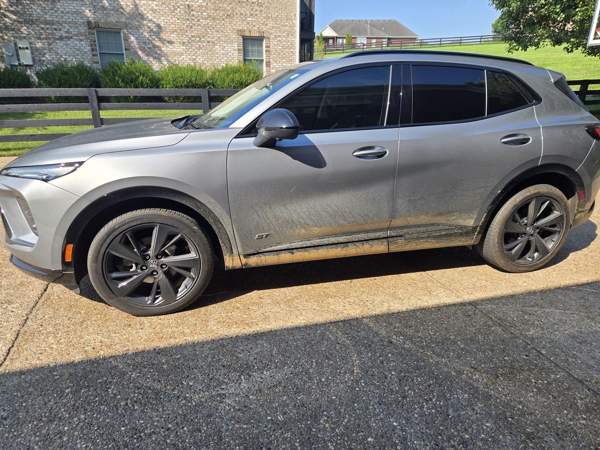 Silver Buick SUV before an exterior detail, covered in road dirt