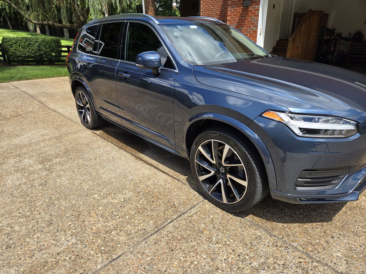 Freshly detailed dark blue Volvo SUV parked on a driveway